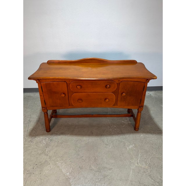 Vintage 1950’s Solid Maple Colonial Storybook Buffet or Sideboard. Whimsical details abound in this piece, from the curved...