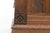 A vintage rectangular wooden chest with a sloped, molded lid, paneled sides with burled wood insets, carved floral rosette...