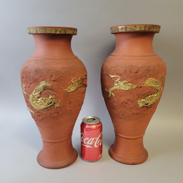A striking pair of Japanese Tokoname terracotta vases, each standing an impressive 15 inches tall and decorated with...