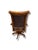A classic wood swivel armchair featuring warm-toned wood, gracefully curved arms, and rich brown leather upholstery with...