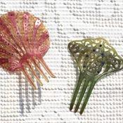 A lovely rhinestone and celluloid comb with a scroll pattern and large combs. Green and vivid blue in color. Antique in...