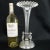 A cast pewter base with a raised platform holds a tall clear hand blown glass vase with a crimped mouth. A pair of...