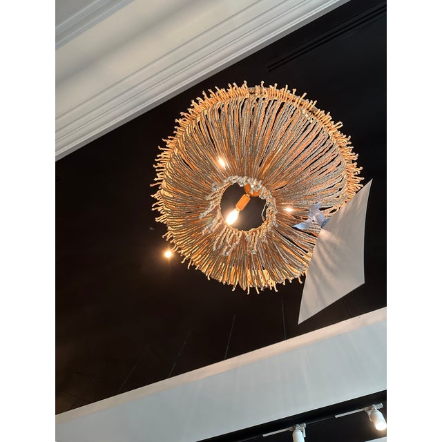 Loops of coco beads, in a flirty, draped silhouette, meet in a tassel of swaying fringe. Dimensions: 30"D x 29"H Elegant...