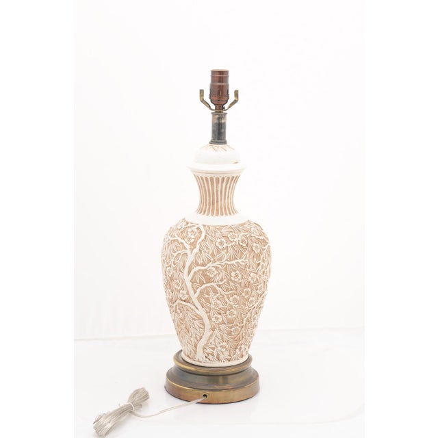 An elegant pair of porcelain mid-century Chinoiserie table lamps in the Hollywood Regency style. Each lamp features a...