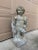 A stunning cast stone statue of a draped cherub or putti holding grapes. This allegorical statue is reminiscent of...