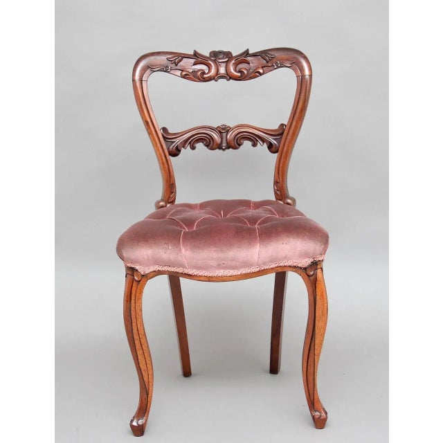 This set of six 19th-century rosewood dining chairs features carved foliate backs and overstuffed seats. The chairs are...