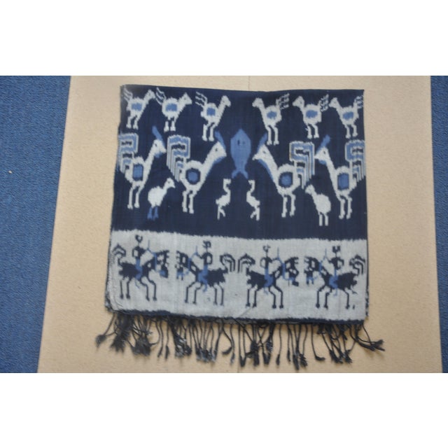 This is a cloth with the following characteristics: warp ikat, not printed decoration predominantly indigo and...