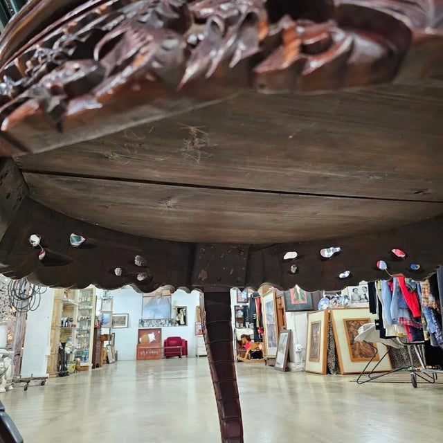 A very nice and finely carved antique Chinese elm center table, circa 1890. The table has a circular top with a carved...