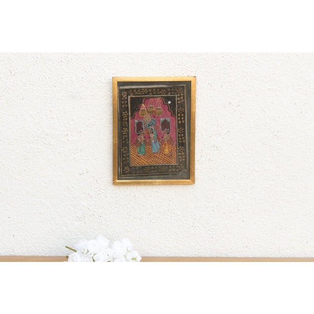 A vibrant piece of Indian devotional art, this small painting captures a classic scene from the life of Lord Krishna. The...