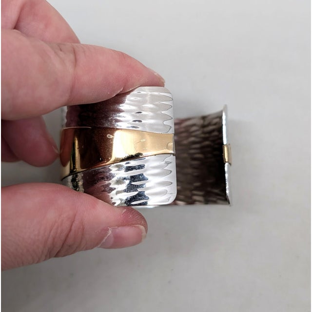 1976 Modernist textured rhodium plate with goldtone stripe cuff bracelet. Marked "Napier." Measures: 2 3/8 inches wide by...