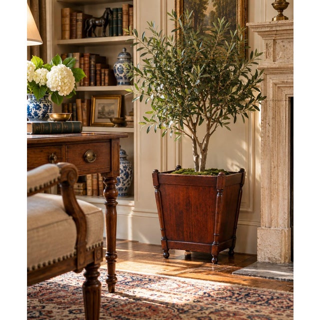 A handsome mid-20th-century mahogany planter or wastebasket, distinguished by its tapered form, turned corner supports,...
