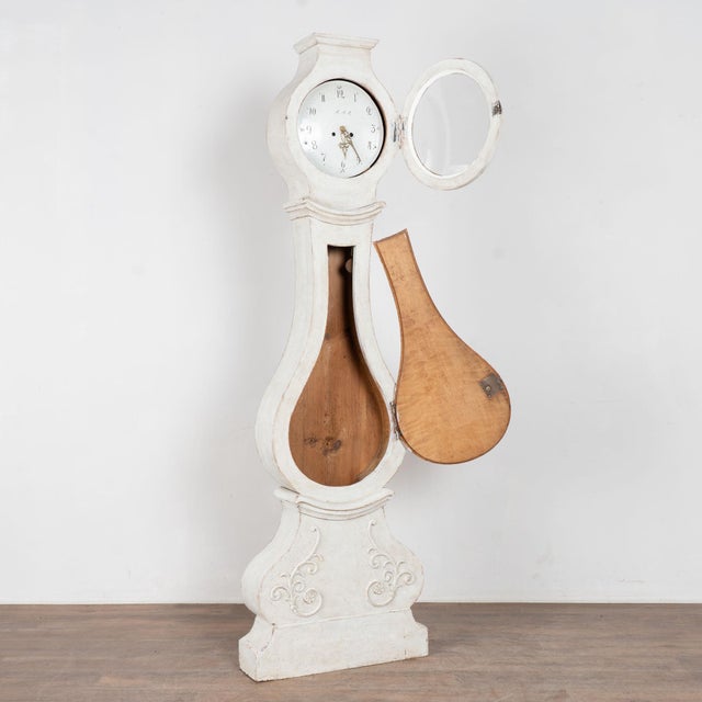 Early 19th century Swedish Mora grandfather clock crafted in pine, standing over 7 feet tall. The case features curvaceous...