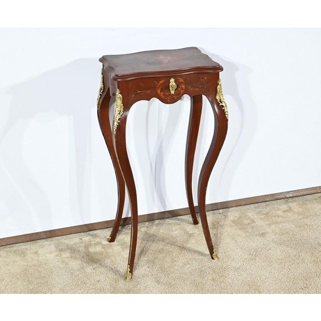 This lacquered wooden work table has an eventful lid in Doucine mounted on hinges and embellished with a polychrome...