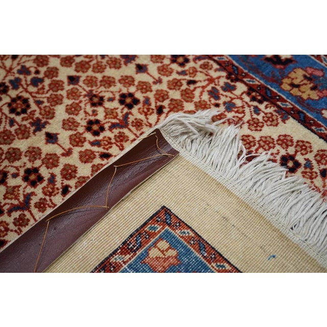 On a creamy sand ground are set five offset rows of oval, open floral motives accented in chocolate, dark blue and salmon-...