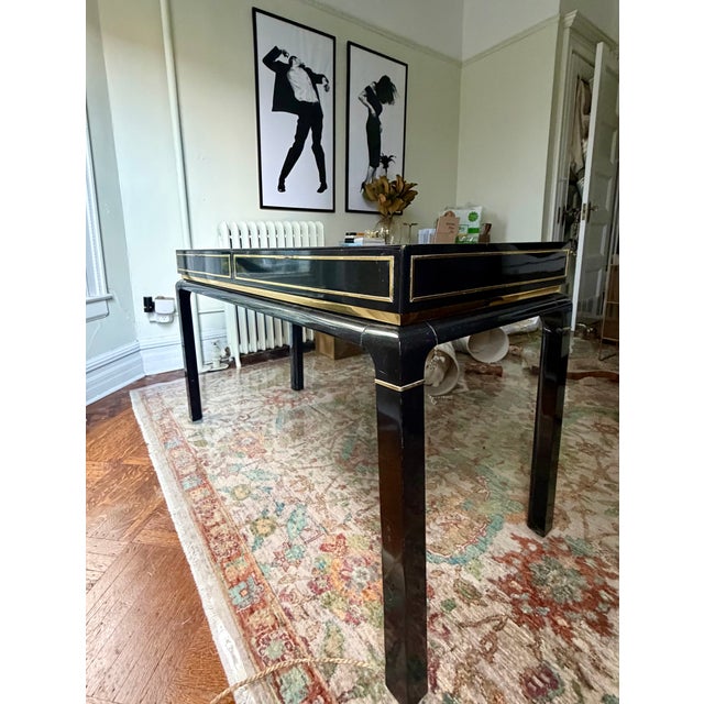 Statement piece desk. Lacquered black finish with brass accents. Two drawers. Minor wear due to age. Otherwise, in great...