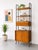 Vintage Mid Century Modern Italian wall unit featuring warm teak and a sleek black metal frame. This architectural piece...