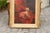 An English late 19th century oil painting of a dog sitting in an armchair with red cushion in giltwood frame. This...