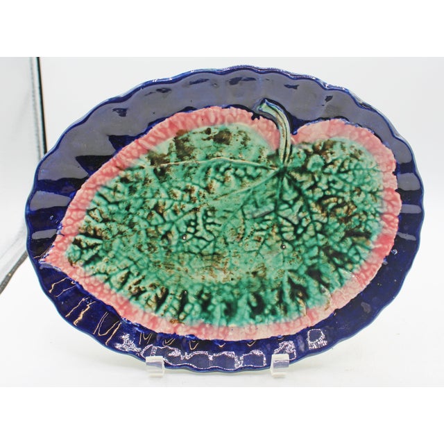 Circa 1880s pair of majolica begonia leaf sweetmeat dishes, English. Scalloped cobalt bordered. Each decorated with a...