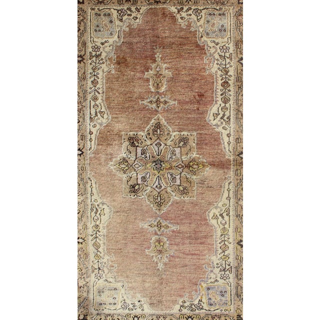 This vintage Turkish Oushak rug features an intricately beautiful design with a stylized floral aesthetic. The central...