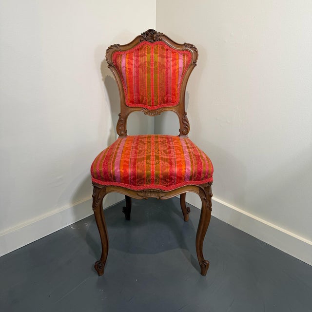 Vibrant color is easily borough to any space with this beautiful and elegant set of Louis XV style walnut side chairs....