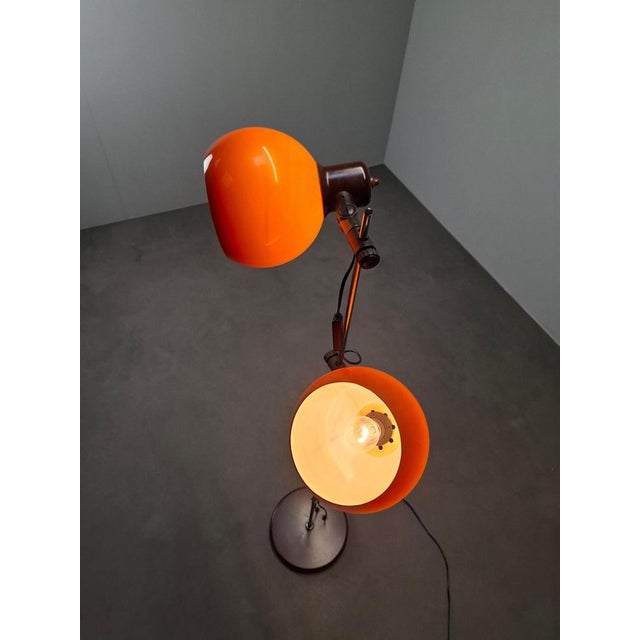Mid-century floor lamp produced in hungary circa the 1970s, featuring two vibrant orange globe shades and a sleek metal...