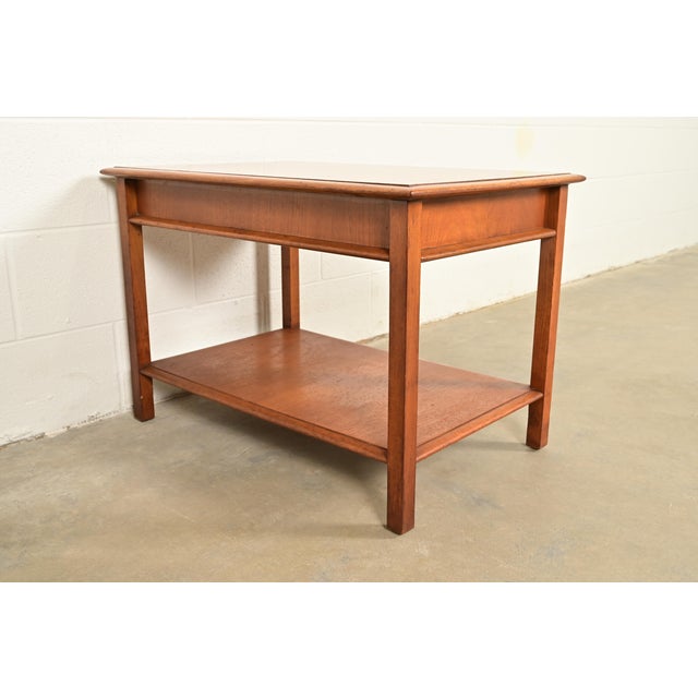 A gorgeous Mid-Century Modern sculpted walnut two-tier nightstand or occasional side table By T.H. Robsjohn-Gibbings for...