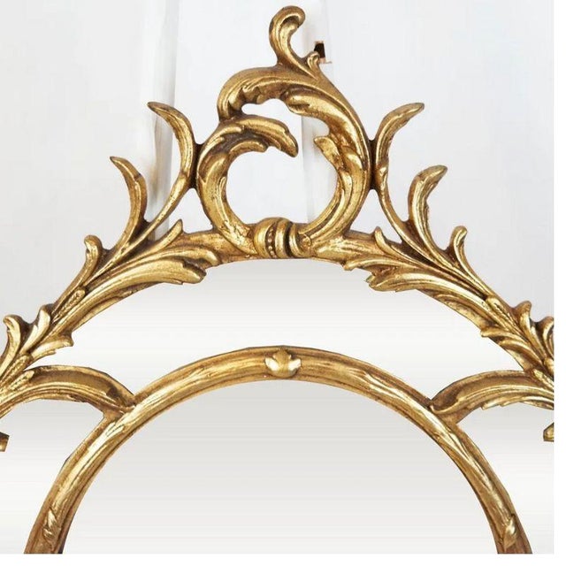 An oval giltwood mirror with scroll motif. A double frame mirror with a beveled edge to the larger, center mirror and a...