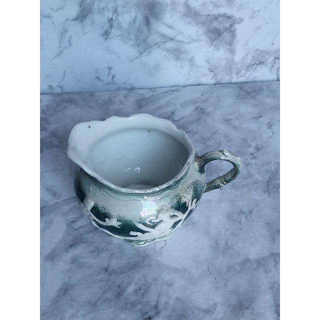 This is an Unger and Schilde lusterware white porcelain creamer with a peralescent glaze and scalloped rim. Circa 1900...