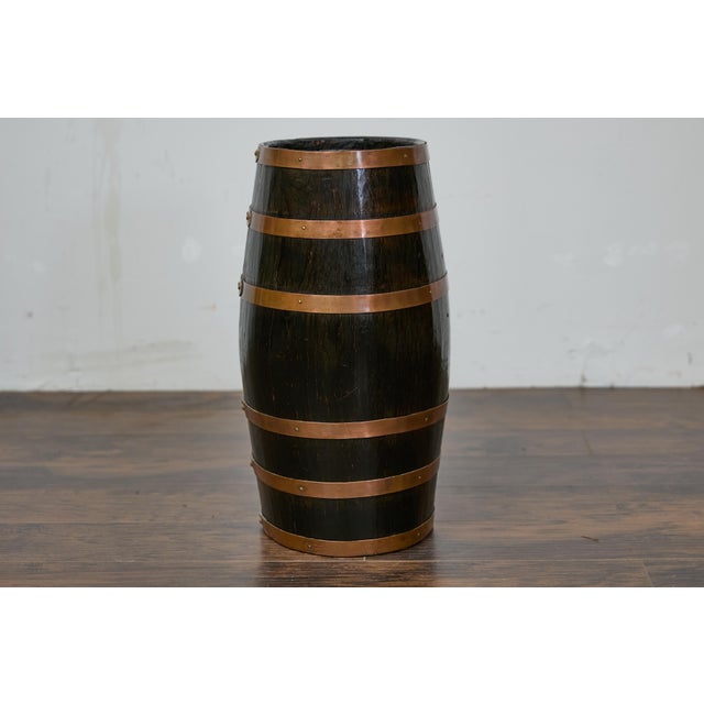 An English wooden barrel from circa 1900 with copper braces and transfer British Royal Coat of Arms. This charming English...