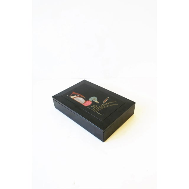 A vintage mid-late 20th century black resin rectangular box with inlaid mallard duck bird on pond with cattail plant...