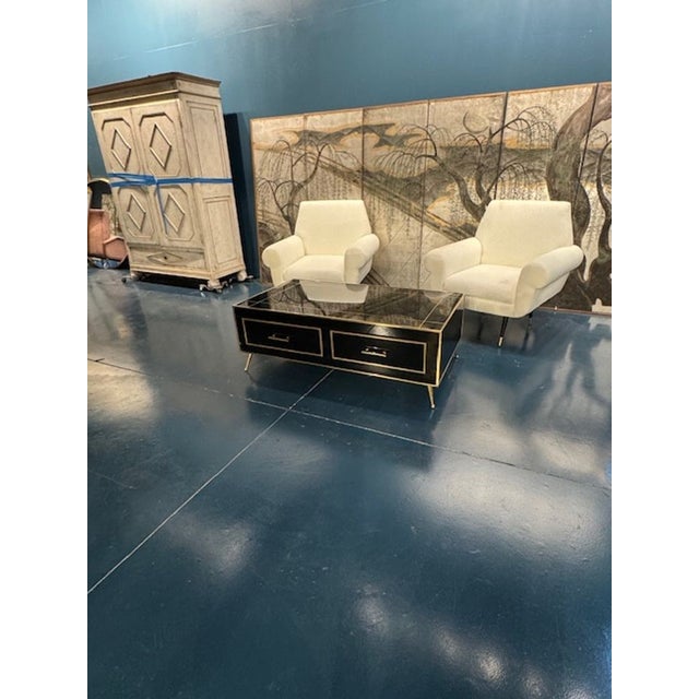 Add a touch of sophistication with this sleek modern black glass and brass low table with 2 drawers. Perfect for the...