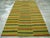 This Mid-20th century Turkish Flatweave Kilim rug, showcases a striking horizontal stripe design set against a vibrant...