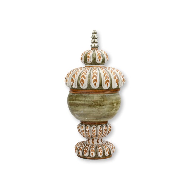 A beautifully sculptural Italian faience lidded urn featuring hand-painted olive green, cream, and warm ochre decoration...