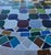 Beautiful round mosaic tile table featuring a vibrant multicolor tiled top and durable black wrought-iron style base. The...