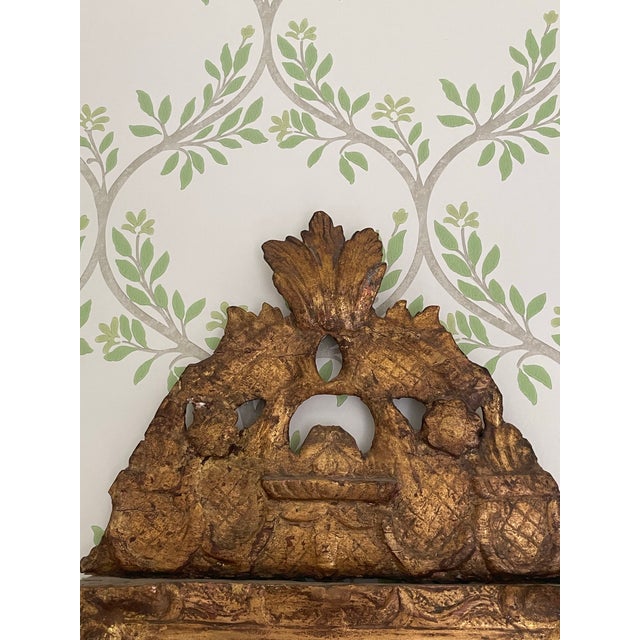 This beautiful Swedish gilded mirror is carved wood with a surmount pediment of baskets and foliage with two rosettes. The...