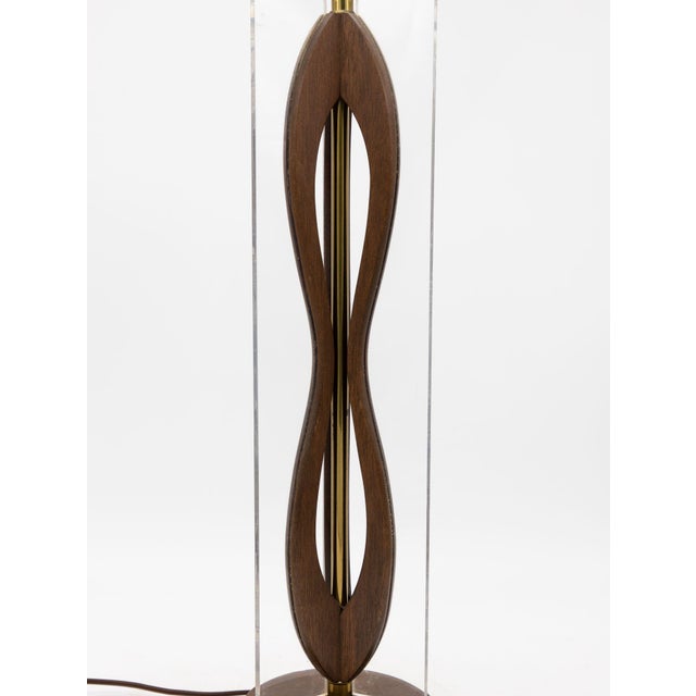 This striking mid-century modern table lamp features an innovative design combining wood and lucite. The base is composed...