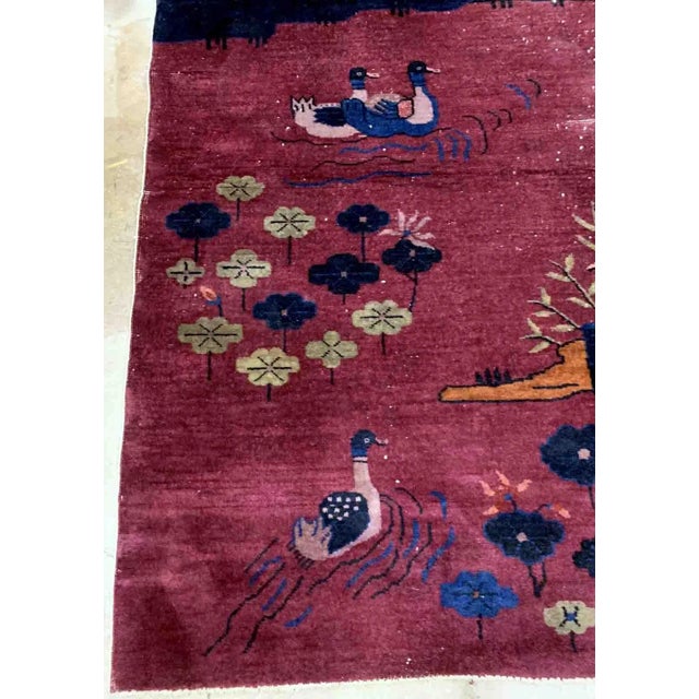 Handmade antique Art Deco Chinese rug in burgundy color with some ducks design. The rug is from the beginning of 20th...