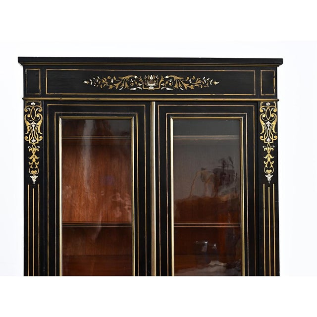 This petite, yet stately bibliothèque, was made in France, circa 1870s. Ebonized and adorned with exceptional brass and...