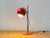 A distinctive table lamp in the pronounced space age design of the 1970s. The spherical, orange-red lacquered metal shade...