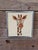 A charming pair of vintage framed needlepoint animal portraits featuring a zebra and giraffe, each beautifully hand-...