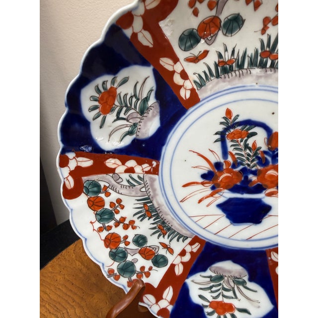 With a center flower basket motif this antique Imari plate is larger scaled and would be a wonderful addition to your...