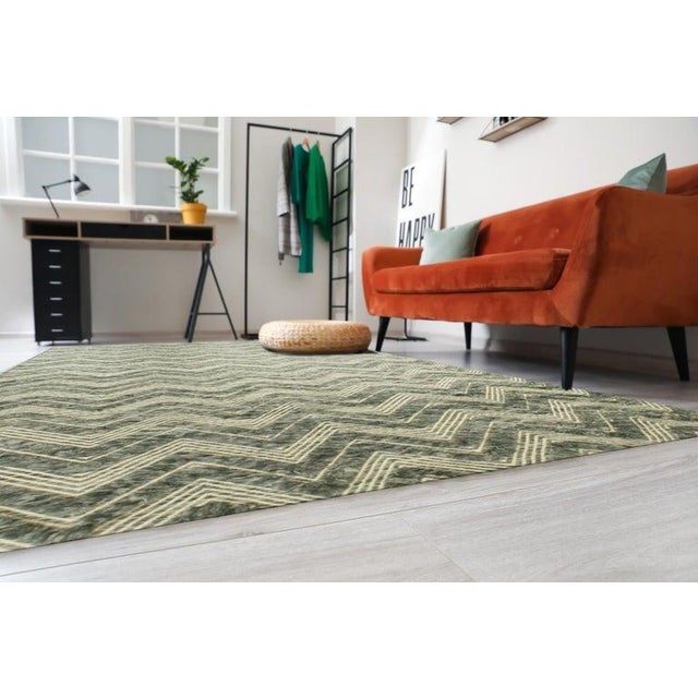 This Green Wool rug features a Hand Knotted Pile weave type. Originating from India, this floor covering presents a...