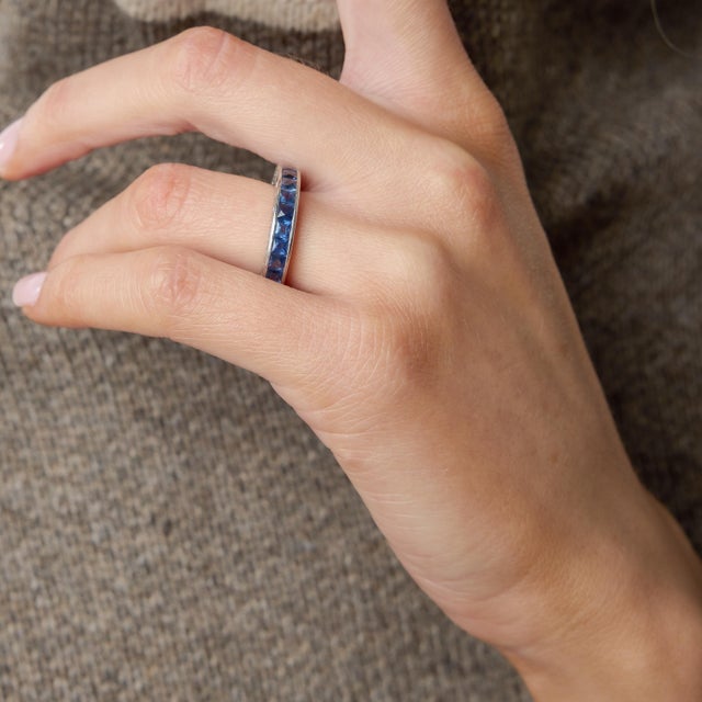 A striking embodiment of 1930s design, this authentic Art Deco eternity band showcases twenty-five meticulously set French...