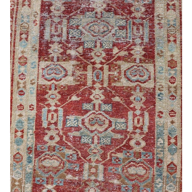 Measures: 2'9" x 14'10" This magnificent antique Persian Heriz runner from the 1910s showcases a stunning array of rich...