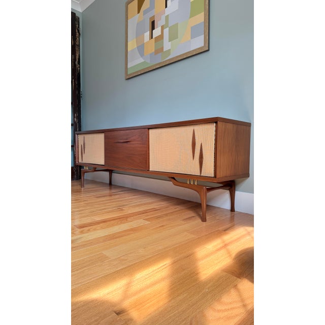 Circa 1950s. Fully refinished and purposefully reimagined. Long and low, featuring rich walnut grain, drop down center...