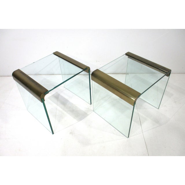 A pair of elegant plateglass and brass side tables from the Pace Collection designed by Leon Rosen whose company was well...