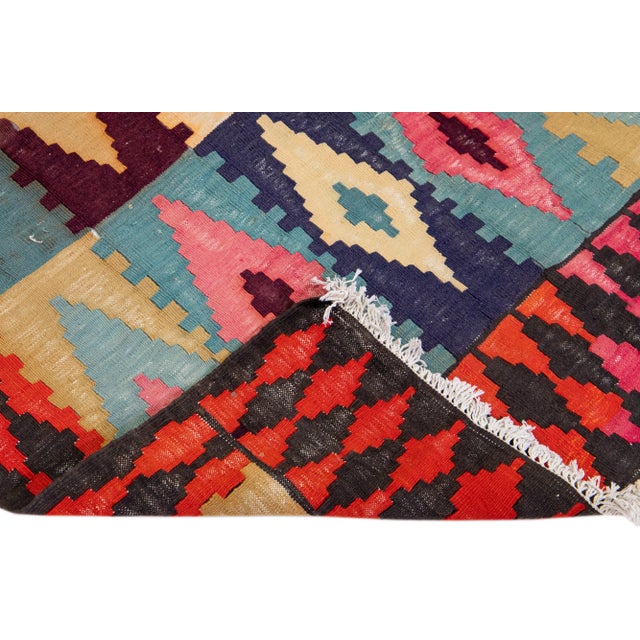 Beautiful vintage Turkish Kilim hand-knotted wool rug with a red field. This piece has an orange frame and multicolor...