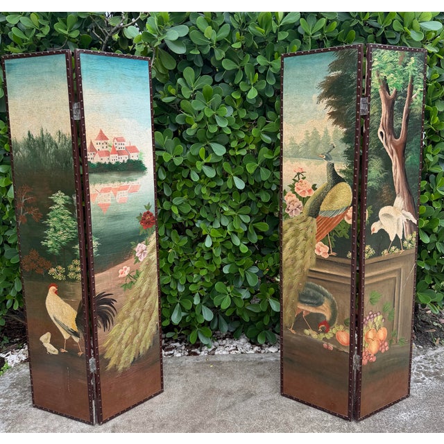 A striking vintage four-panel folding screen featuring wonderfully detailed hand-painted scenic imagery, including a...