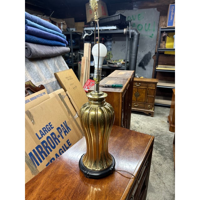 A substantial vintage brass table lamp attributed to Stiffel, featuring a classic fluted urn-form base with a warm...