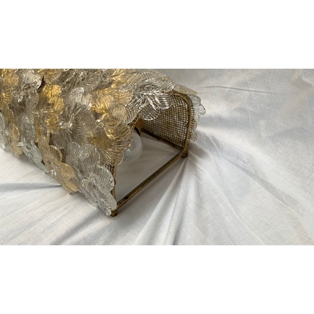 This is an art glass wall lamp with a sophisticated and scenic design. The gold-painted iron frame is entirely covered...